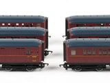 three red and blue train cars sitting next to each other on a white surface