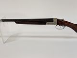 un fusil posé sur un support, devant un fond blanc