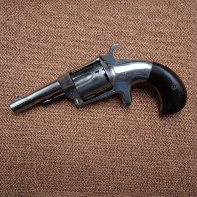 a close up of a revolver on a brown background
