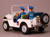a toy jeep with two people in it on a gray surface