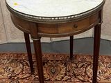 une petite table avec un plateau en marbre posée sur un tapis