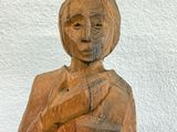 a wooden statue of a woman holding a baby