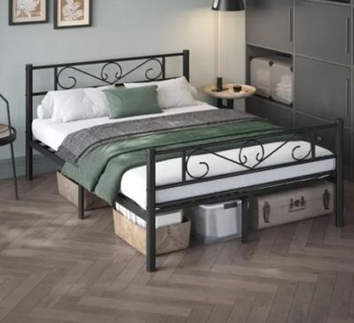 a bed with a metal frame and a green blanket