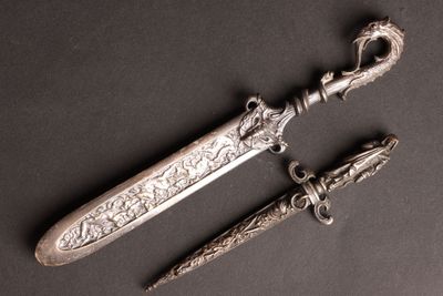 une image représentant un poignard en argent et un couteau sur un fond noir
