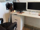 a computer desk with two monitors and a chair in front of it