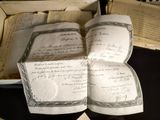 three old books sitting on a table with papers on it