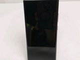 the back of a black cell phone sitting on top of a white table
