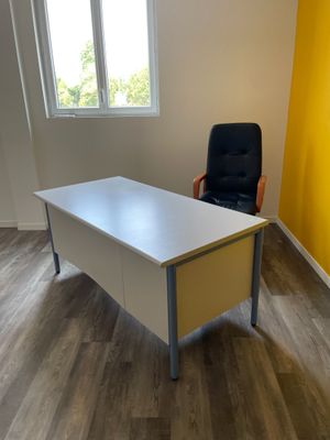 un bureau avec une chaise et une fenêtre dans la pièce
