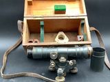 une boîte en bois sur laquelle sont posés un appareil photo et une pipe