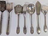 a lot of spoons and spoon knives on the table
