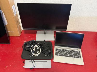 two laptops and a monitor on a red desk
