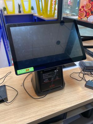 a computer monitor sitting on a desk with a charger