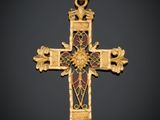 une croix dorée ornée d'un motif floral sur fond noir