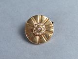 a close up of a gold brooch with pearls on it