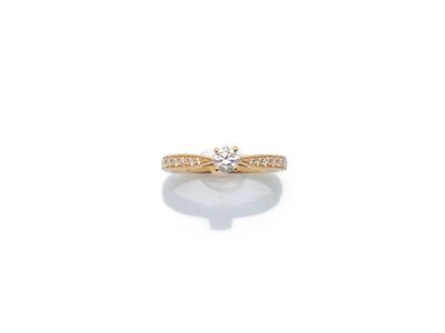 une bague en or sertie d'un diamant sur fond blanc