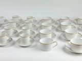 a lot of cups and saucers sitting on a table