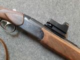 the rifle is laying on the floor next to a brown cord