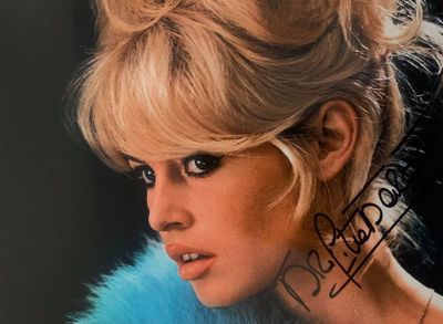 une femme blonde vêtue d'un manteau de fourrure bleu posant pour une photo
