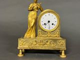 a gold clock with a statue on top of it