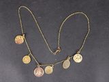 un gros plan d'un collier orné de pièces de monnaie sur un fond noir