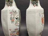 two white vases with asian designs on them sitting on a table