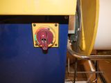 a yellow and blue machine with a red button