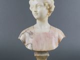 a white marble bust of a woman on a pedestal