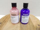two bottles of hair products sitting on a wooden table