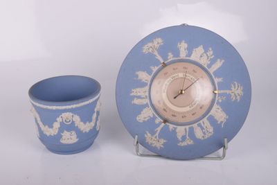 une horloge bleue et blanche et une tasse posées sur une table