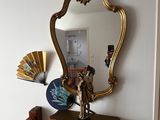 a mirror on the wall above a table with a fan on it