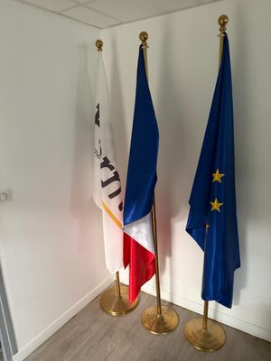 trois drapeaux sont placés les uns à côté des autres dans une pièce