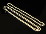 gros plan d'un collier de perles blanches sur une surface noire