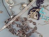 many different types of necklaces and bracelets on the table