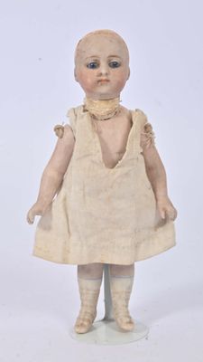 a small doll that is standing on a white surface