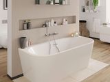 une baignoire blanche installée dans une salle de bains, près d'une fenêtre