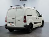 the white van is parked in a large room with a black roof rack