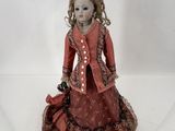 poupée en porcelaine représentant une femme vêtue d'une robe rouge et d'une veste rouge