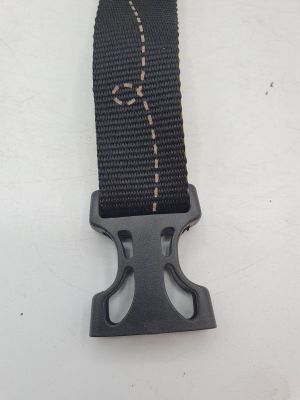Gros plan sur une ceinture dotée d'une boucle métallique, posée sur une surface blanche