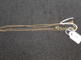 a close up of a gold chain with a tag on it