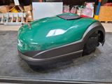 une tondeuse à gazon verte posée par terre dans un garage