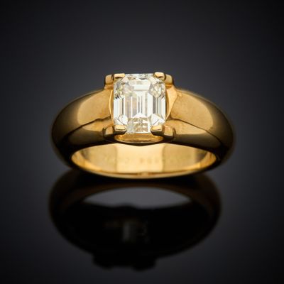 a yellow gold ring with an emerald stone in the center