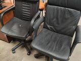 two black leather office chairs sitting next to each other