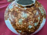 un vase posé sur une table recouverte d'une nappe rouge