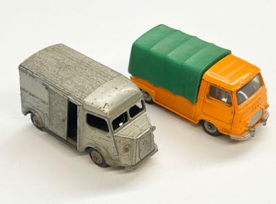 deux camions miniatures posés l'un à côté de l'autre sur une surface blanche
