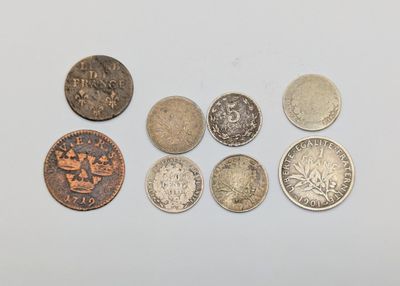 six different types of coins sitting on top of a white surface