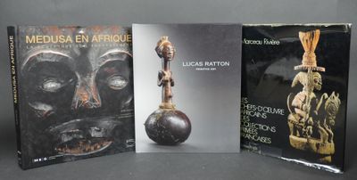 trois livres posés sur une table, devant lesquels se trouvent un vase et une statue