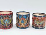 three drums are lined up in a row on a white surface