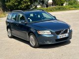 a blue volvo wagon parked on the side of the road
