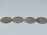 three quarters of the same coin are shown on a white surface