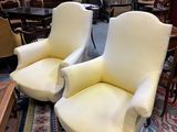pair of yellow upholstered chairs in a room with a rug